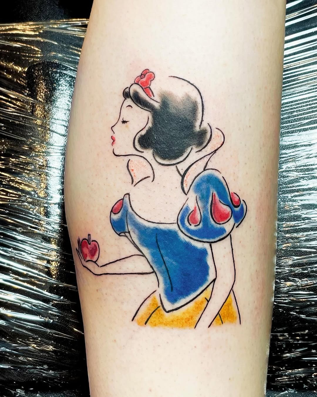 This charming tattoo captures Snow White in her signature style, showing her iconic blue and yellow dress.