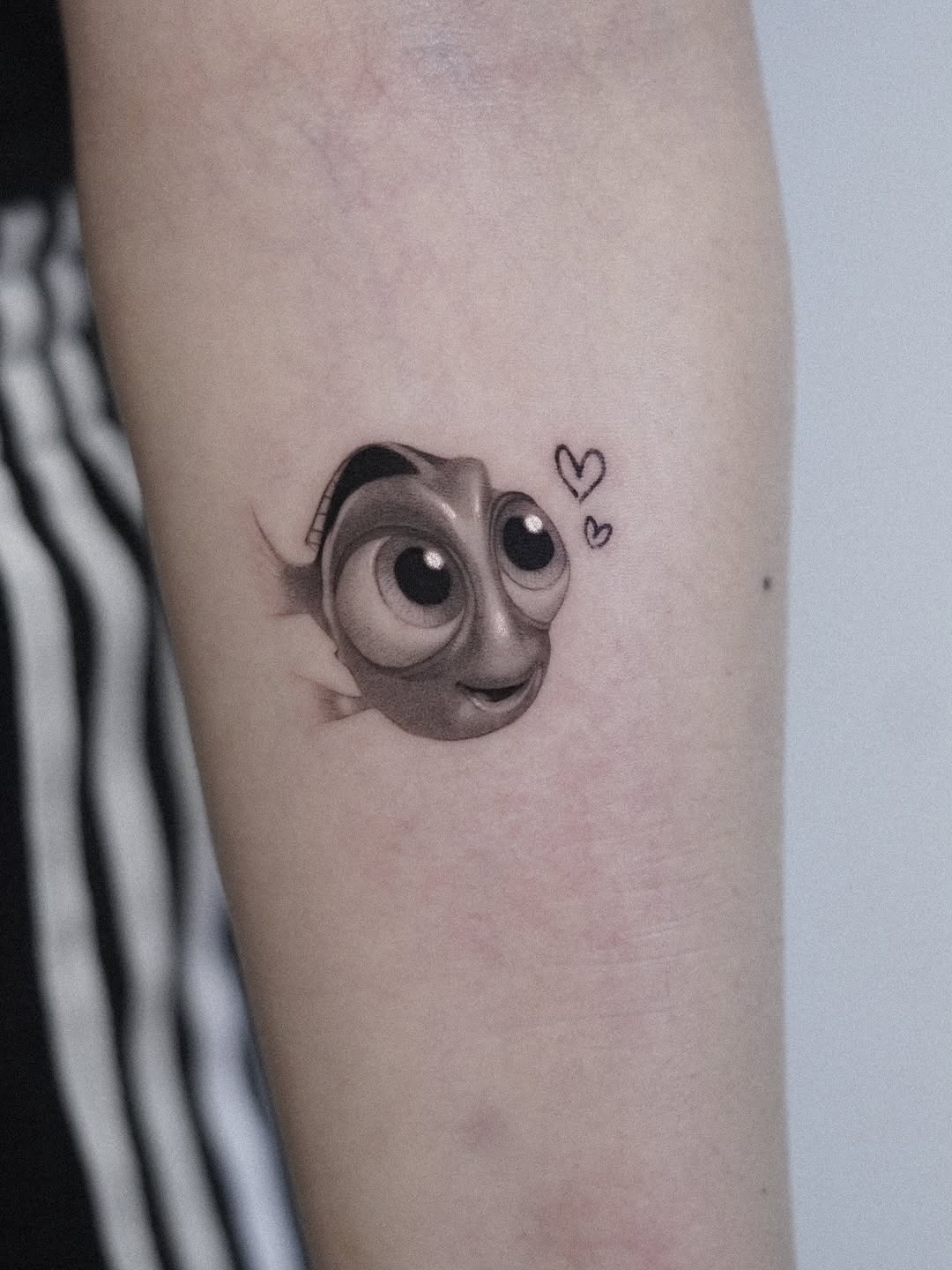 This tattoo features the lovable character Dory from Disney.