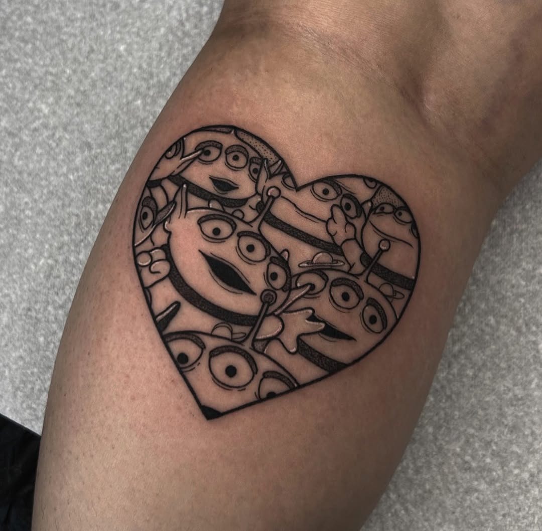 This unique tattoo showcases a heart filled with adorable Disney aliens, bringing a playful vibe.