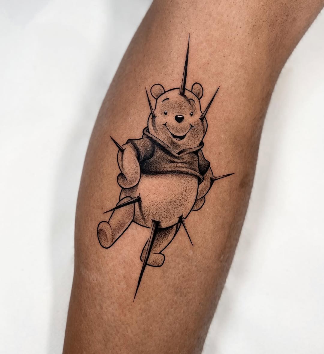 This tattoo features a playful Winnie the Pooh, radiating joy and nostalgia.
