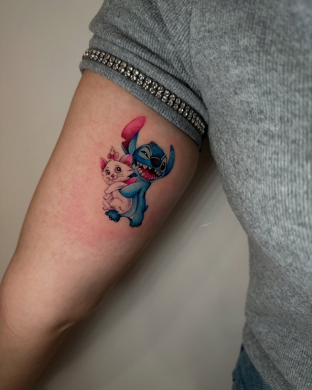 This tattoo features Stitch and Scrump, two beloved characters from Disney's 'Lilo & Stitch.' The lively colors and playful poses create a whimsical vibe, perfect for fans of this iconic duo.
