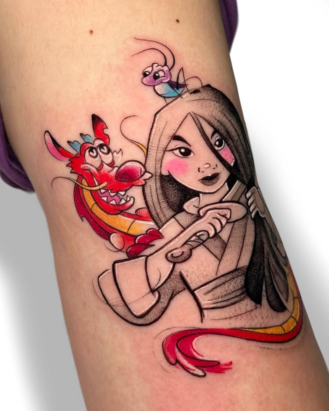 This tattoo features Mulan holding her sword, accompanied by the playful Mushu and the curious cricket.