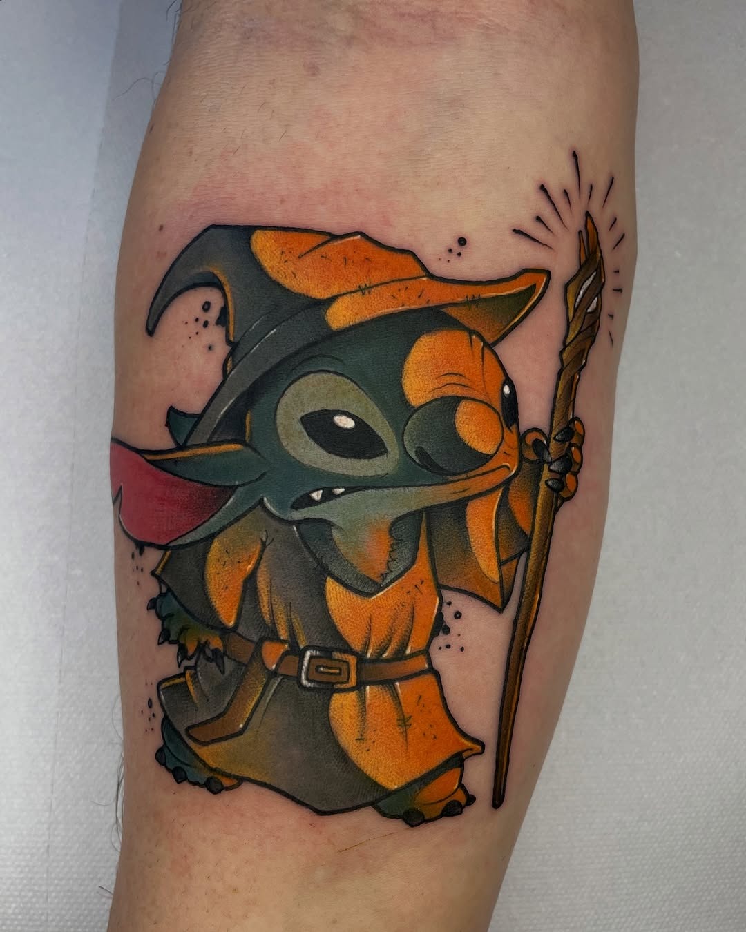 This tattoo features a, whimsical Yoda character styled in a wizard-like outfit.