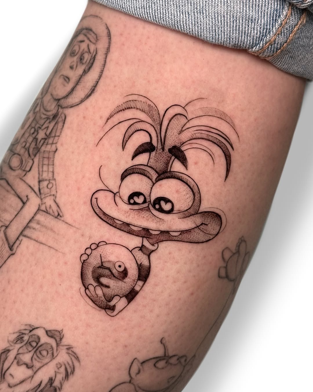 This tattoo features a playful Disney character, showing a fun and quirky style.