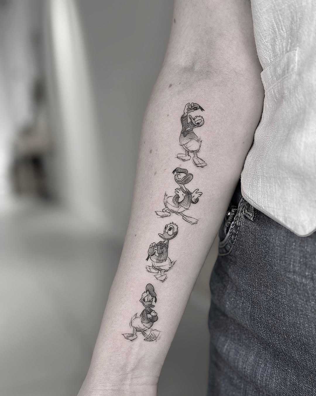 This arm tattoo features iconic poses of Donald Duck, showing his playful and mischievous personality.