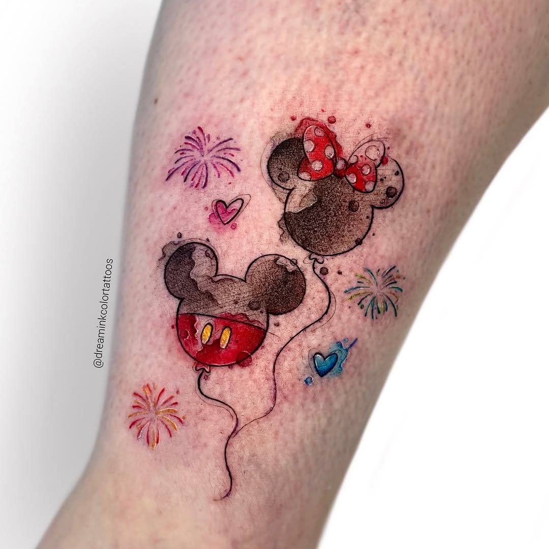 This adorable tattoo features Mickey and Minnie Mouse as playful balloons, surrounded by colorful fireworks.