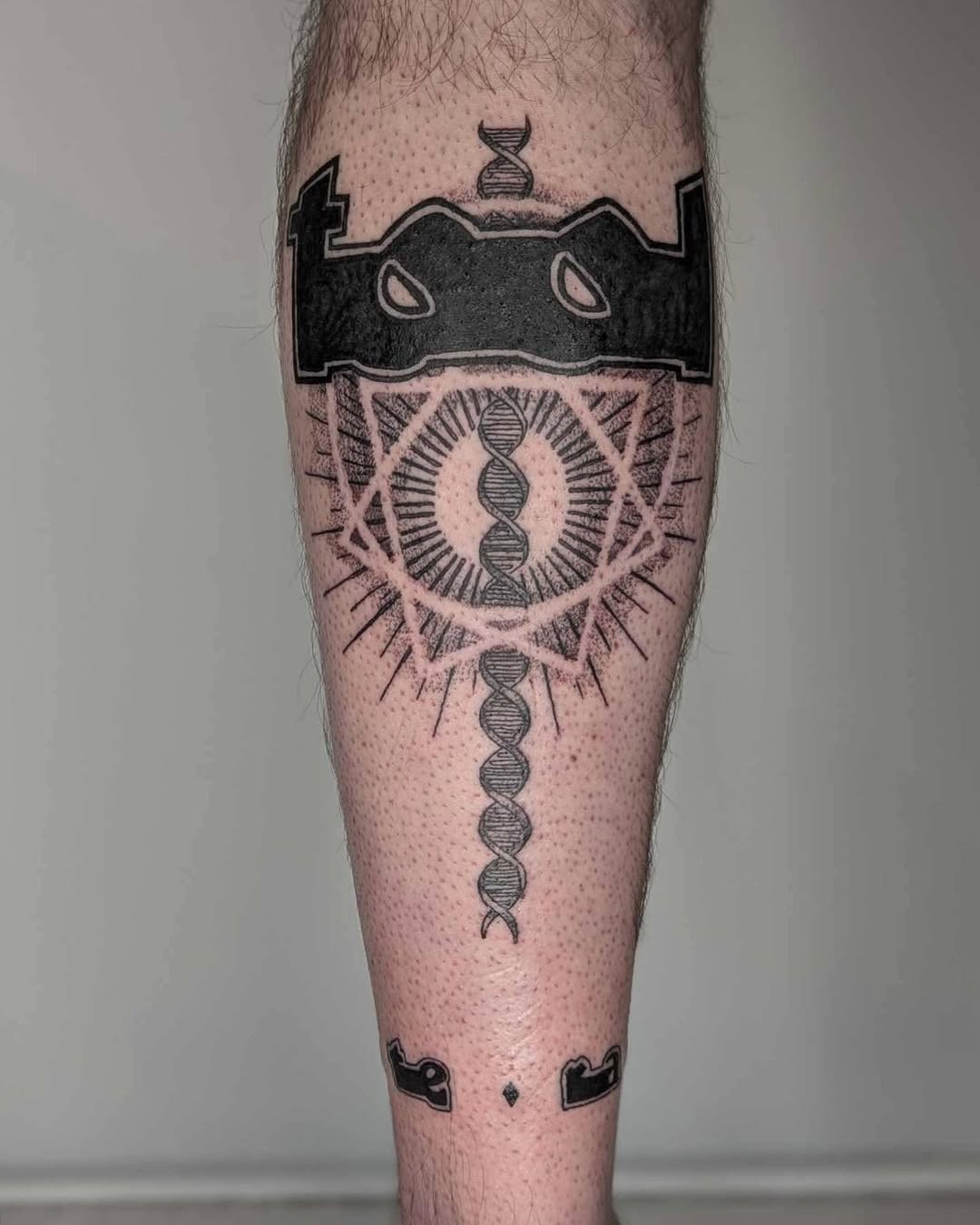 This striking tattoo features a detailed DNA strand surrounded by geometric shapes and symbols.