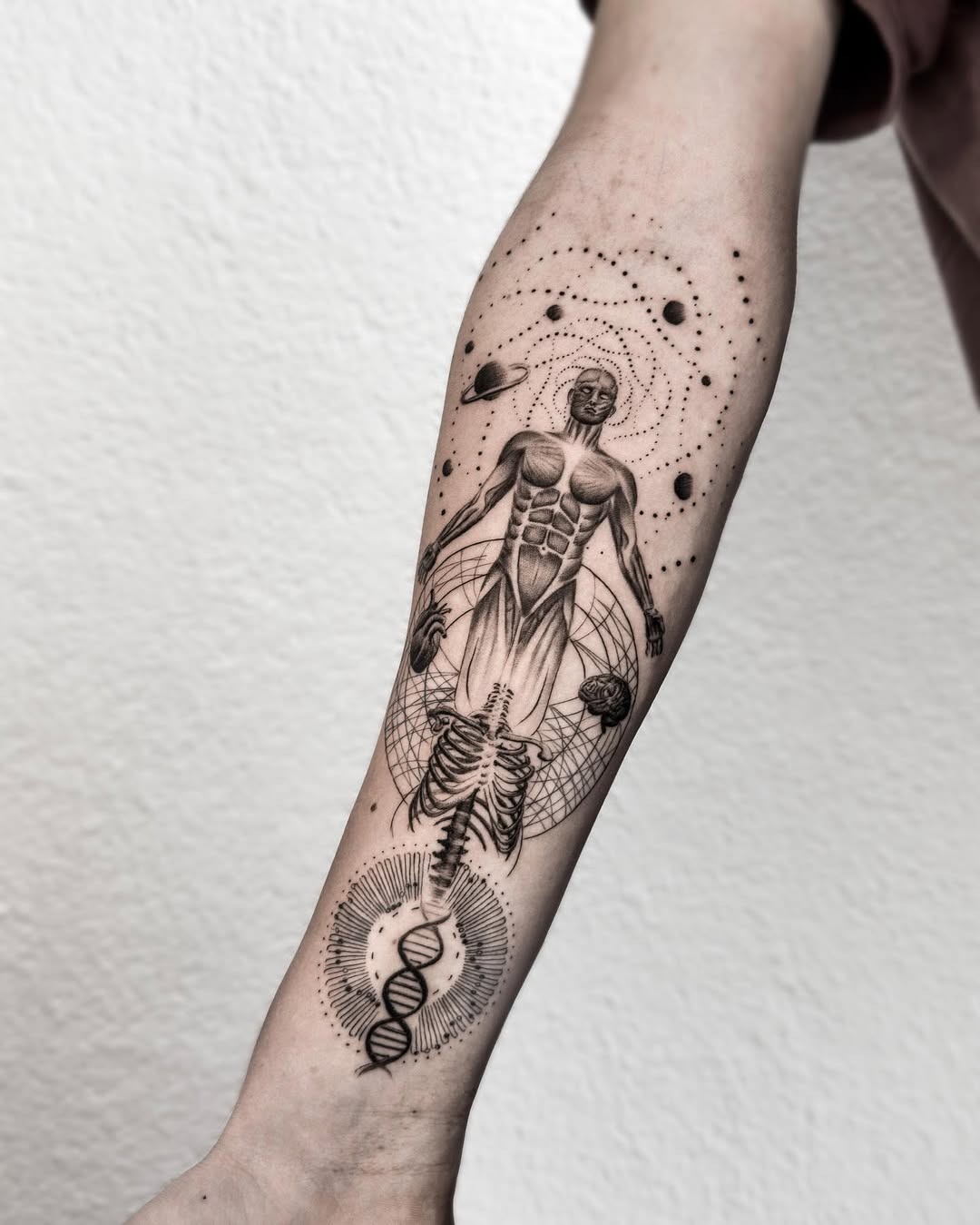This tattoo features an intricately designed human figure intertwined with DNA strands.