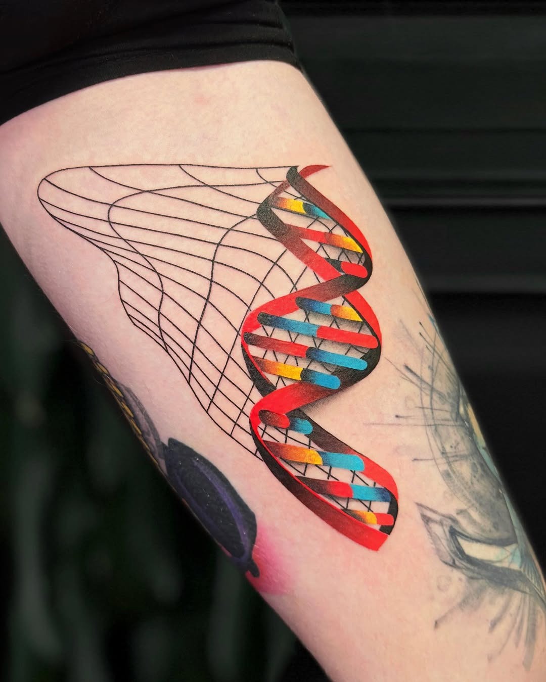 This unique tattoo features a stylized DNA helix with bright, eye-catching colors.