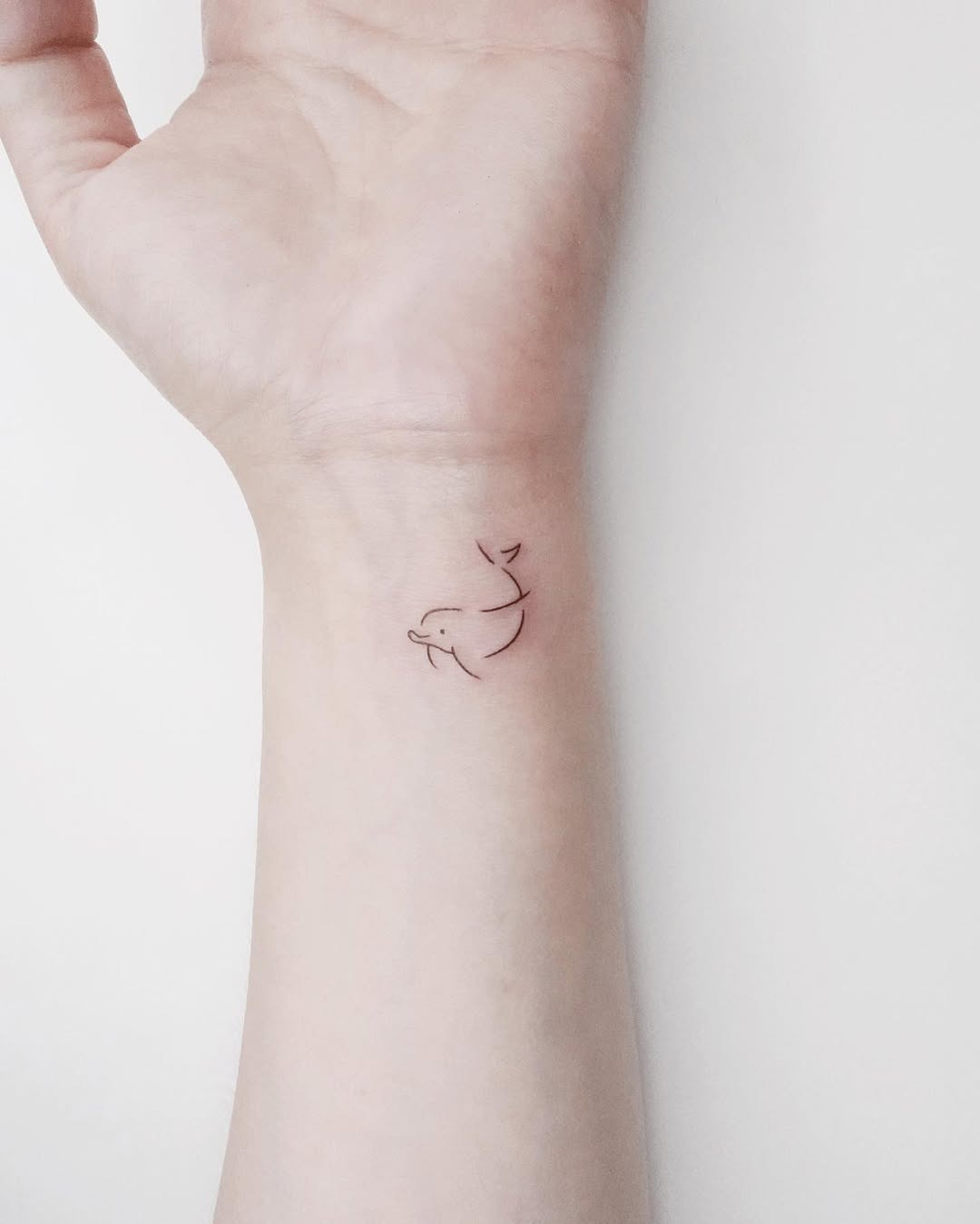 Colorful dolphin tattoo with a splash of life Tattoo Design