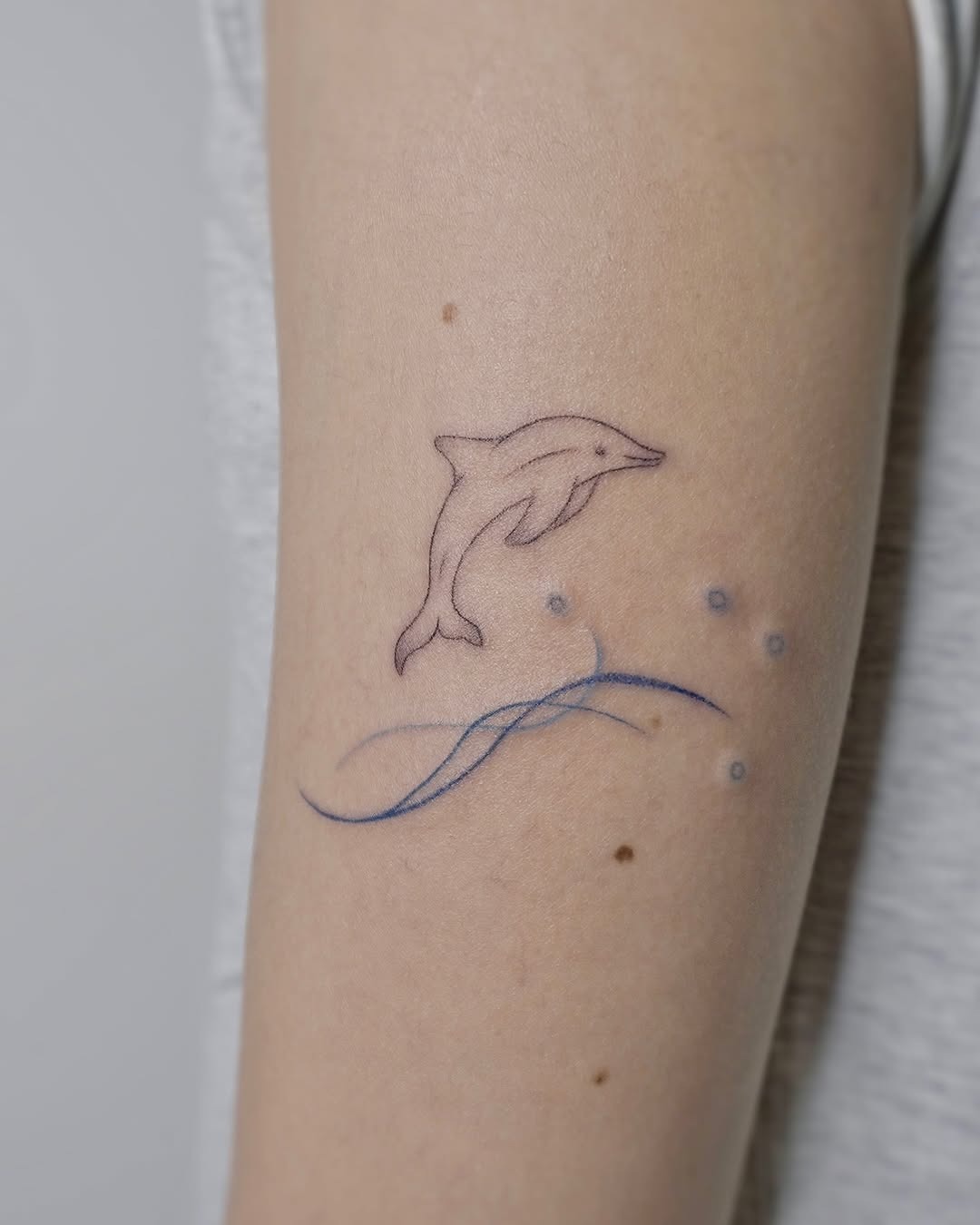 Whimsical dolphin tattoo with ocean waves Tattoo Design