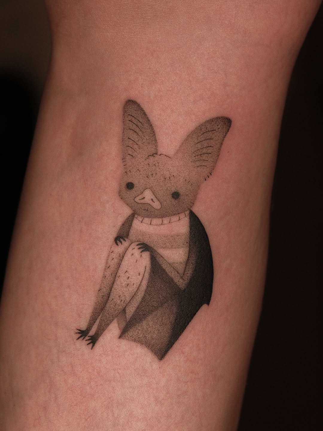 This dotwork tattoo captures a whimsical bat character with fine lines and shading.