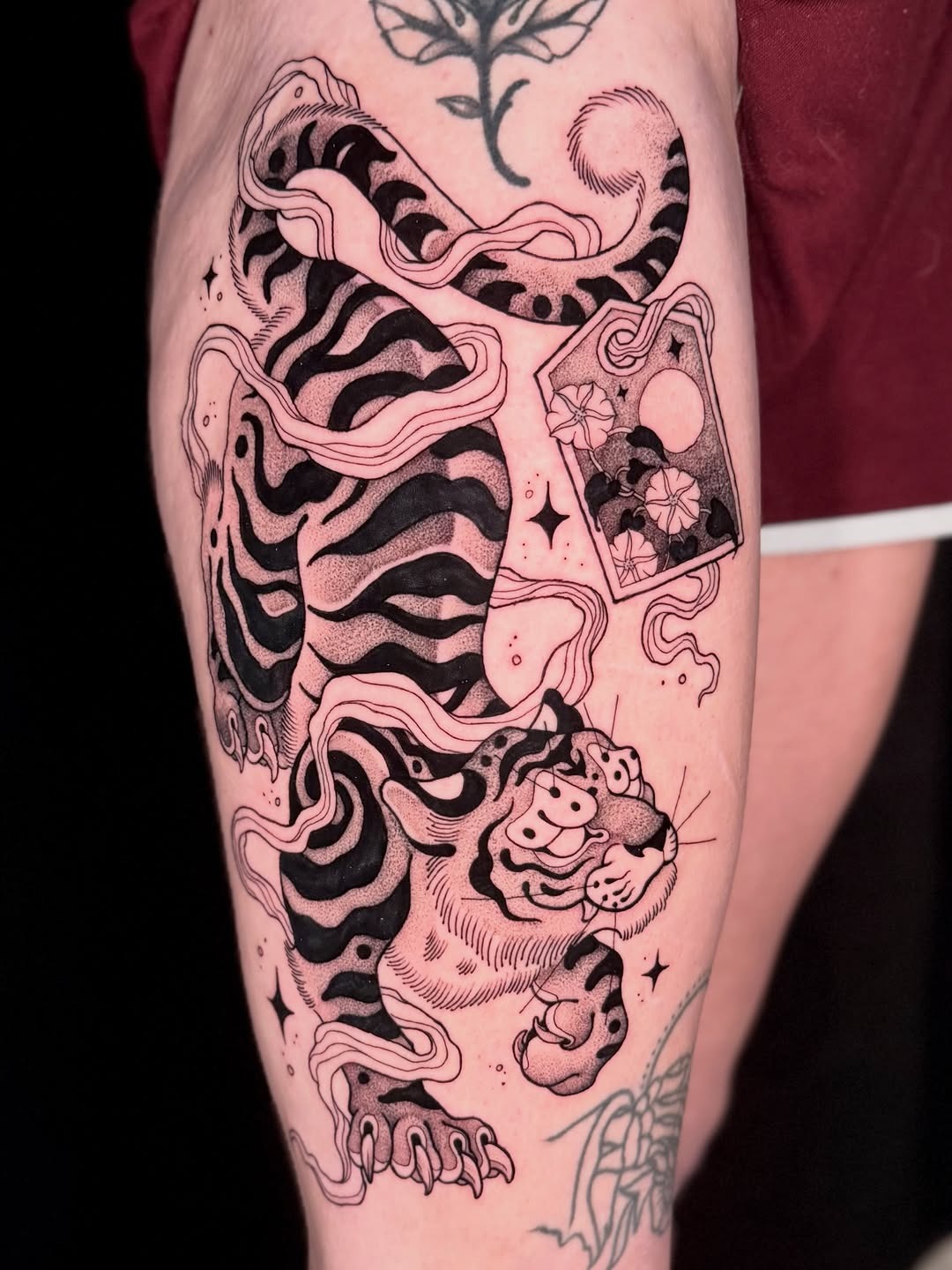 This dotwork tattoo features a striking tiger amidst swirling lines.