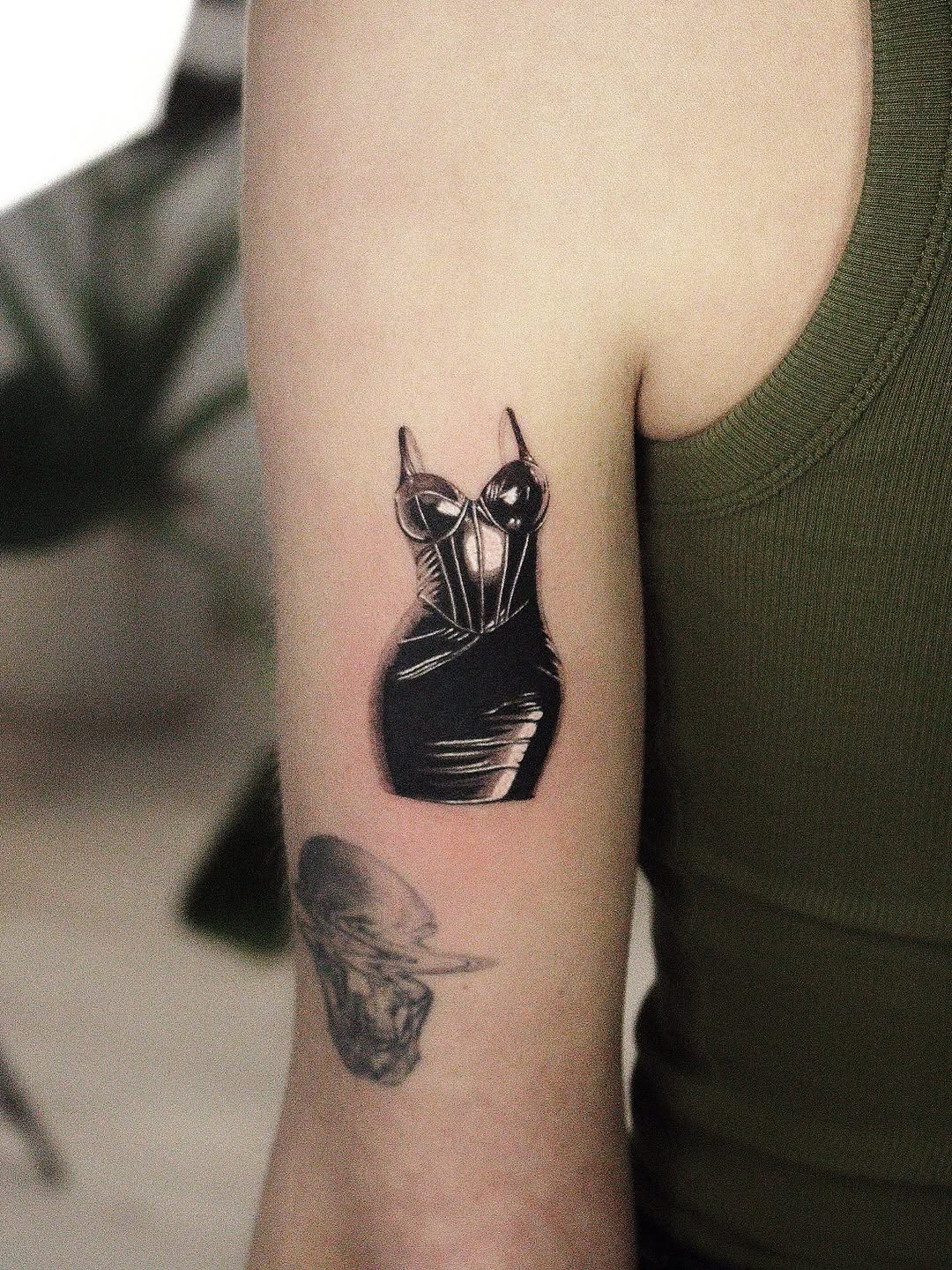 This tattoo features a sleek black dress design, intricately crafted with dotwork techniques.
