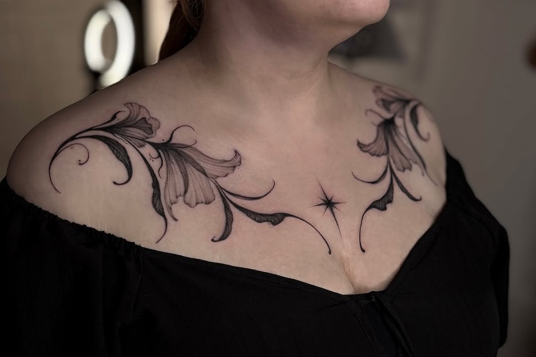 This stunning dotwork tattoo features intricate floral designs elegantly placed on the shoulders.