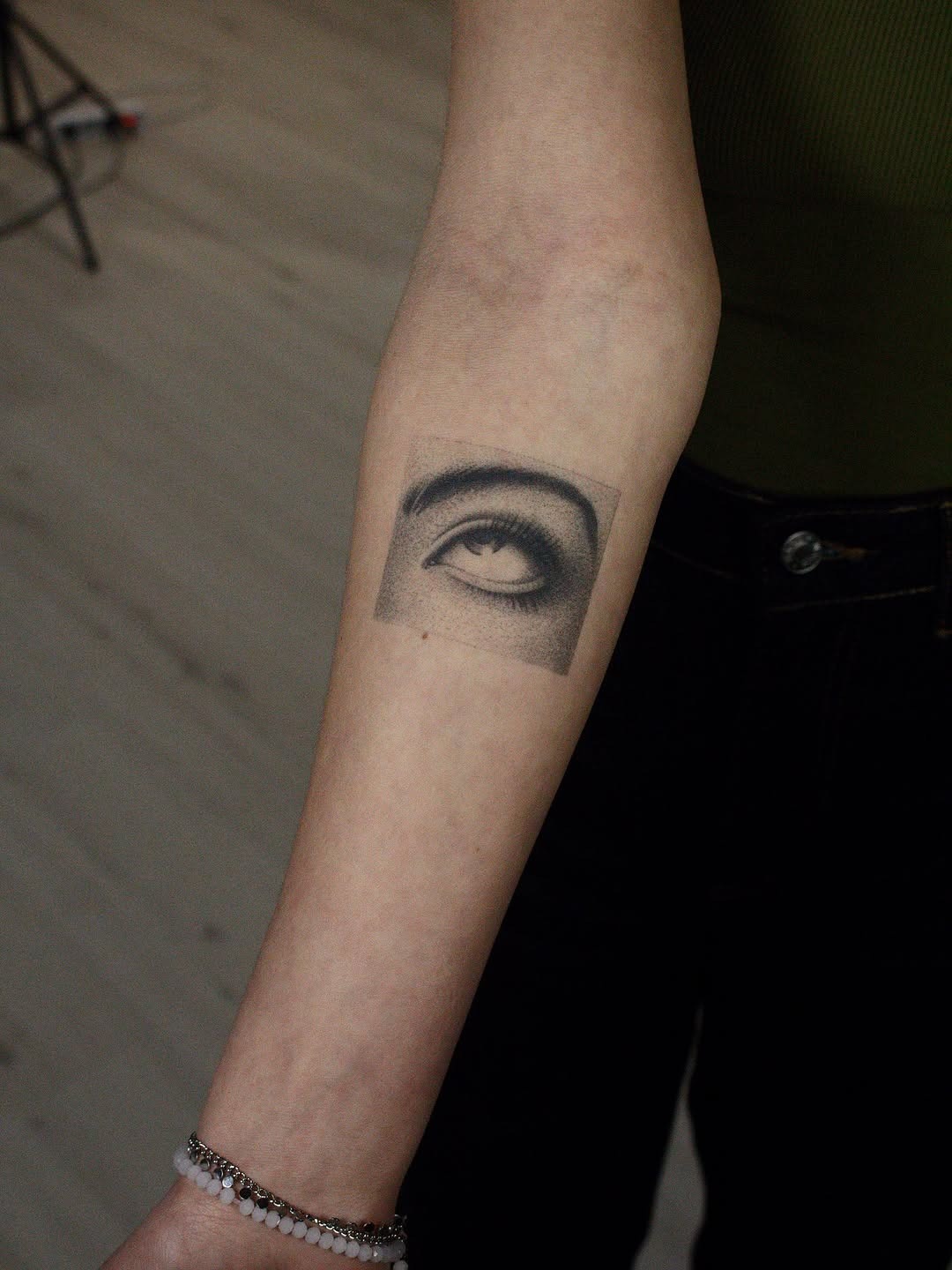 This tattoo features a stunning eye rendered in intricate dotwork style.