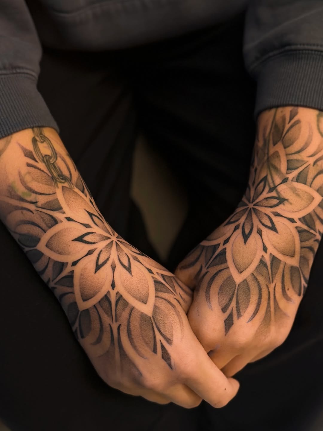 These stunning tattoos feature a geometric floral design, elegantly spreading across the hands.