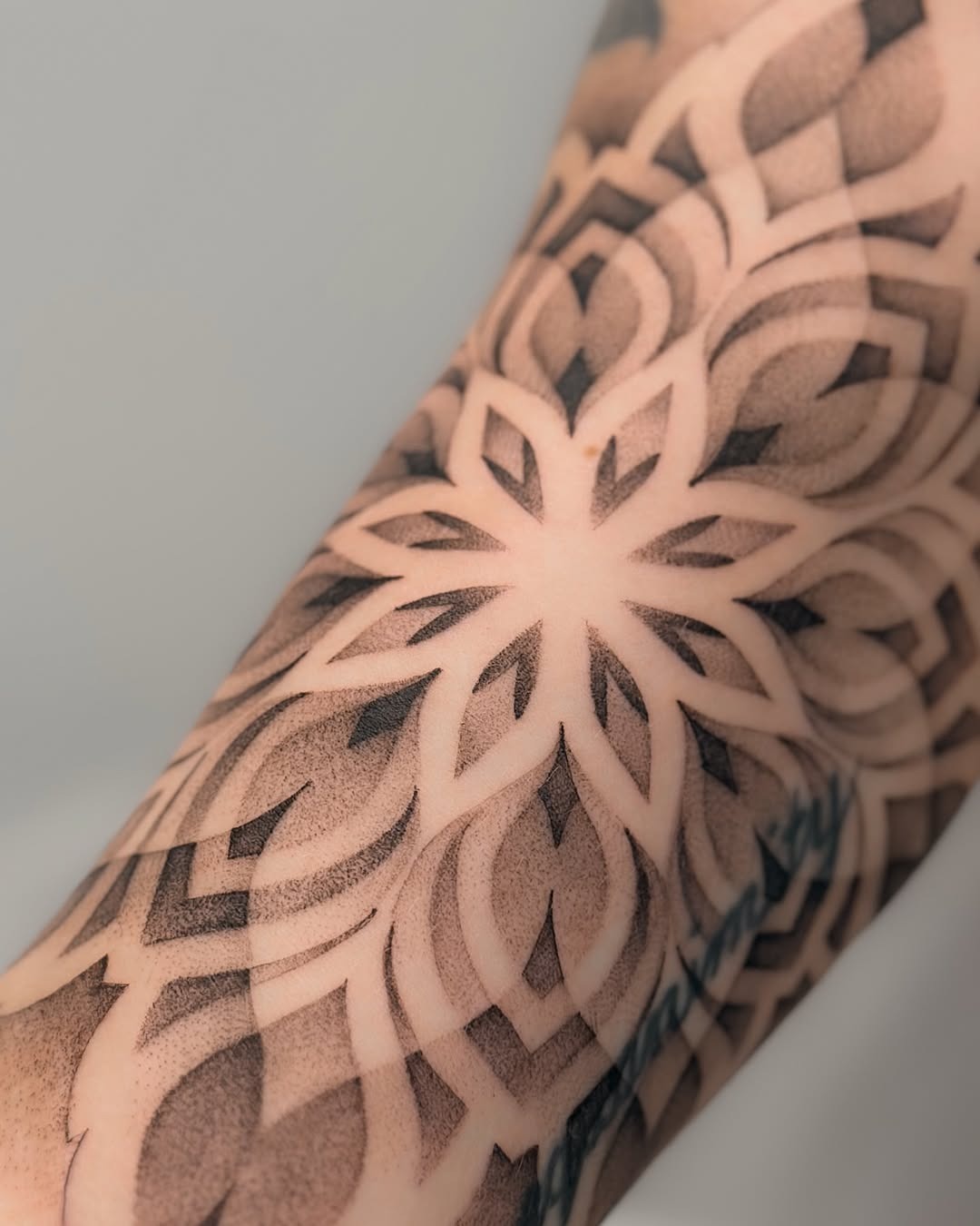 This stunning tattoo showcases a beautiful floral pattern created entirely through dotwork technique.