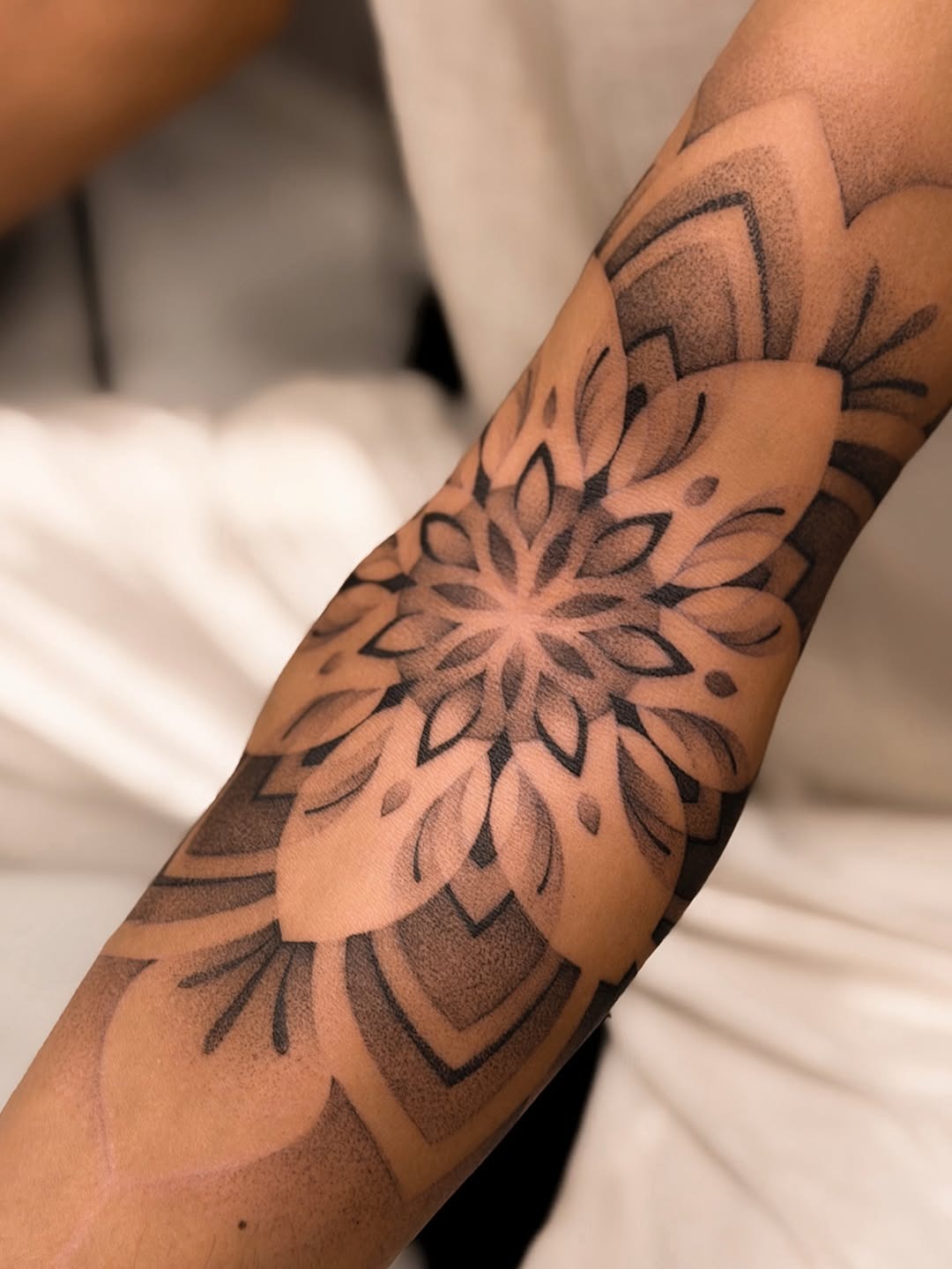 This dotwork tattoo features a stunning mandala pattern that seamlessly blends artistry with body form.