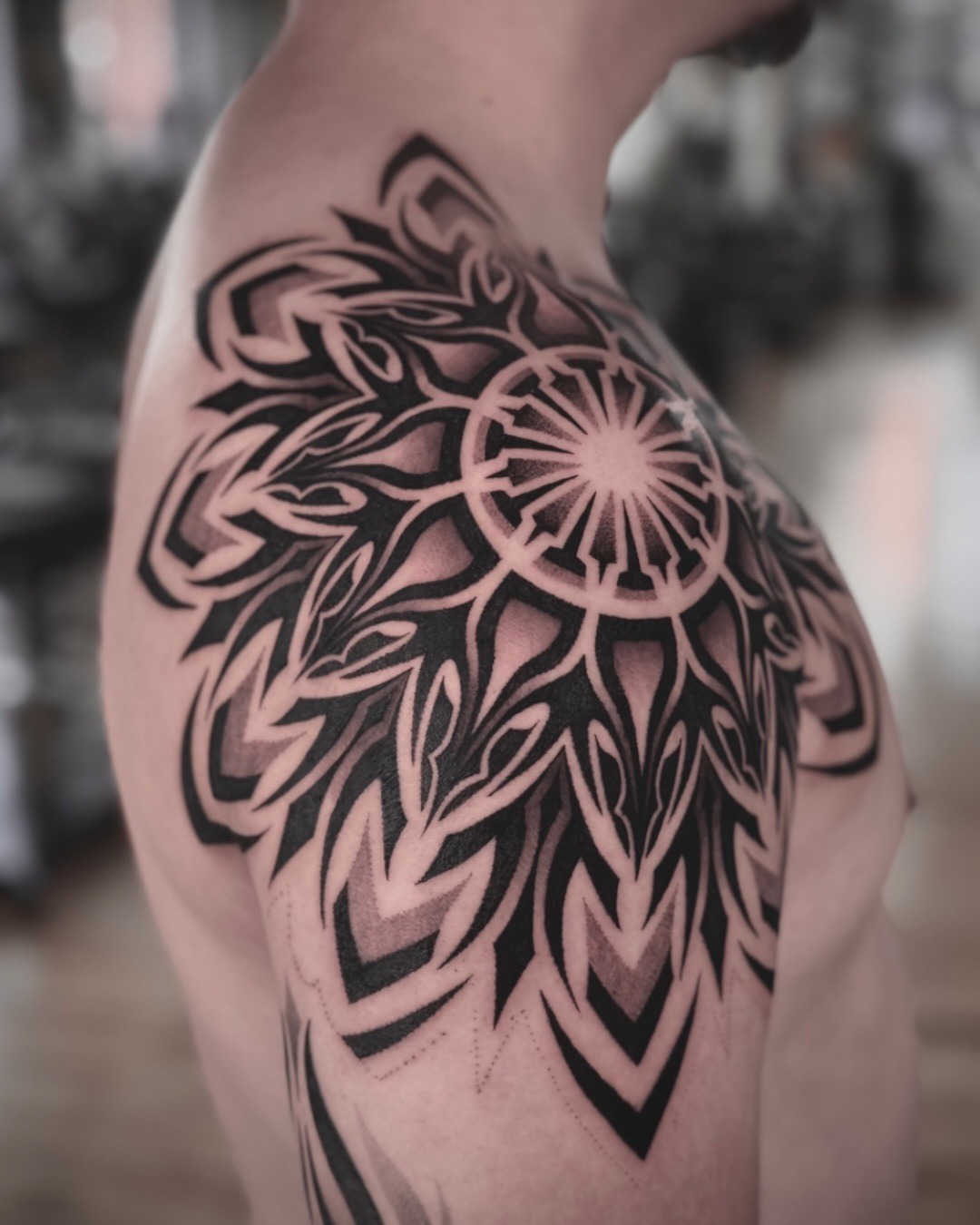 This stunning dotwork tattoo features a large, detailed sunflower design that spans the shoulder.