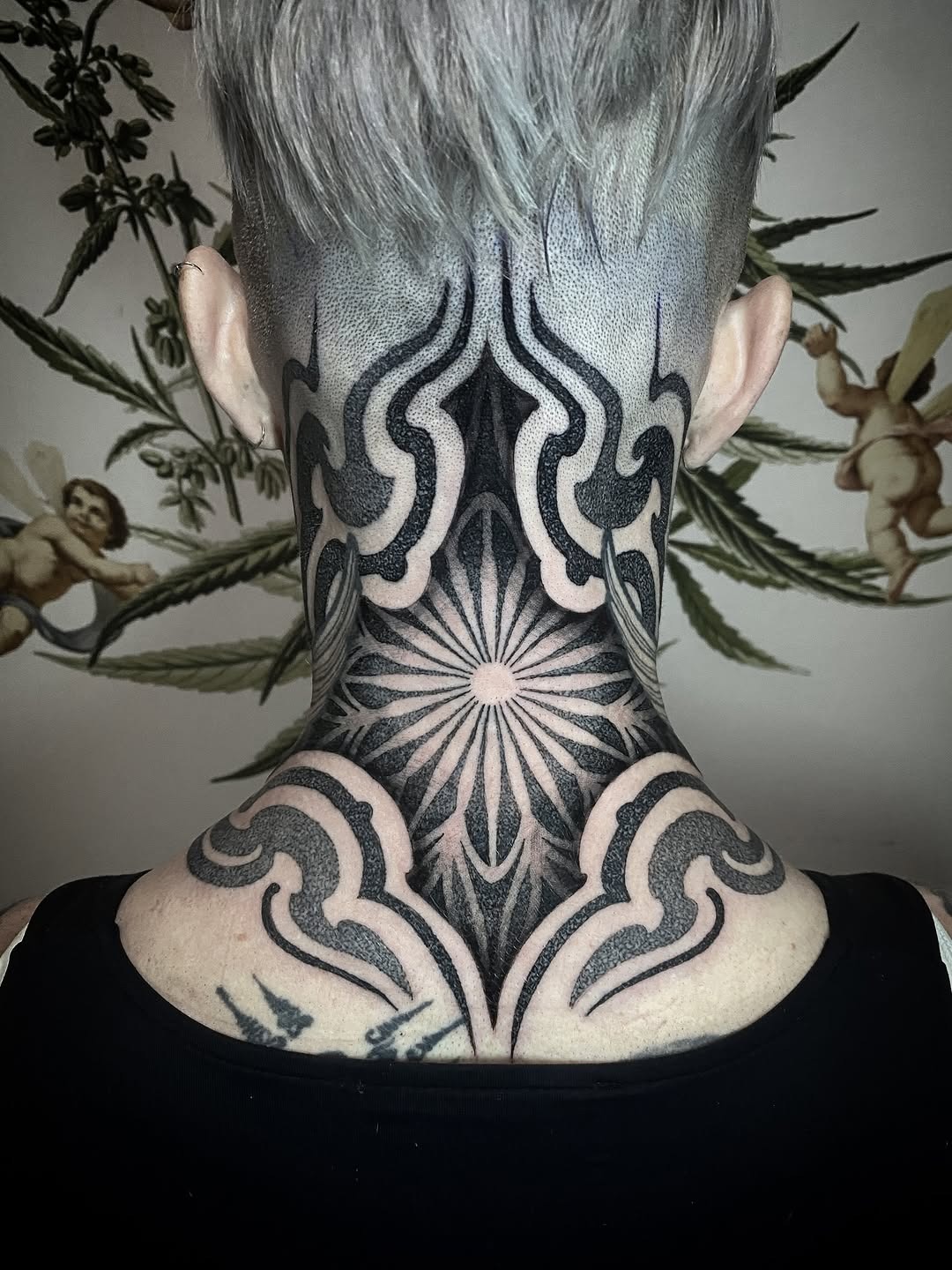This striking dotwork tattoo features detailed geometric patterns that elegantly flow along the neck.