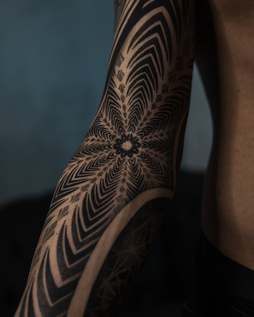 This stunning tattoo showcases intricate dotwork patterns spiraling around the arm.
