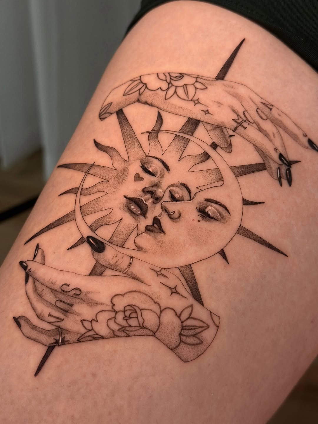 This dotwork tattoo features a beautifully detailed sun and moon design, accented with gentle hands cradling them.