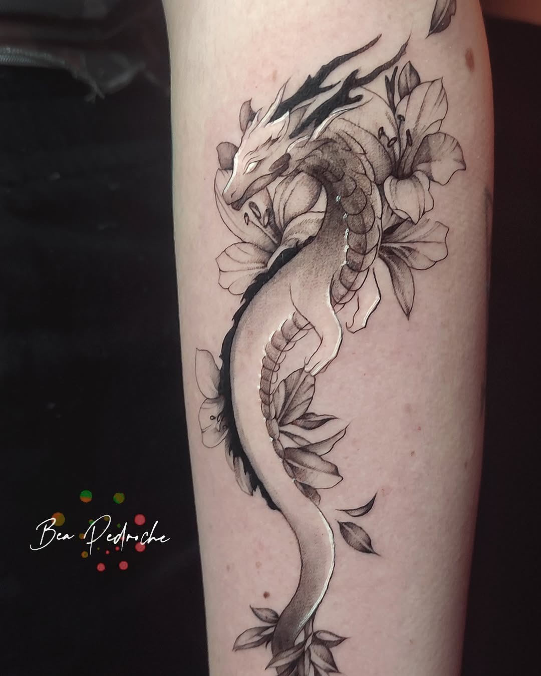 A graceful dragon entwined with blooming flowers Tattoo Design