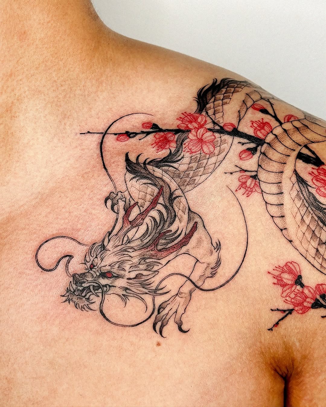 Bold dragon tattoo with floral elements Tattoo Design