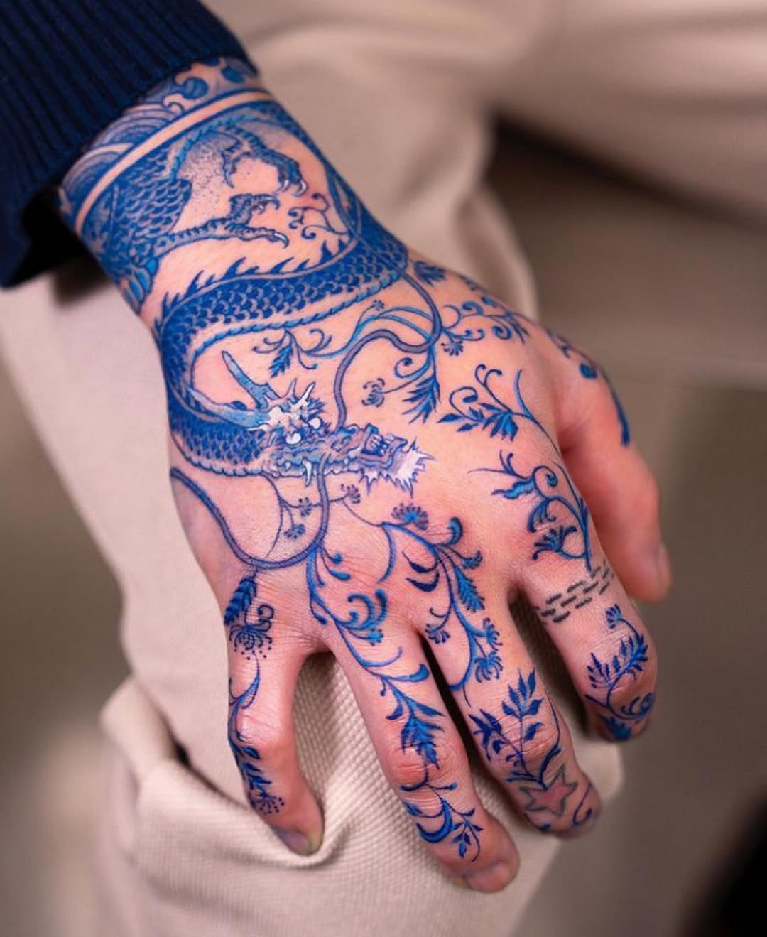 Intricate blue dragon tattoo on hand. Tattoo Design