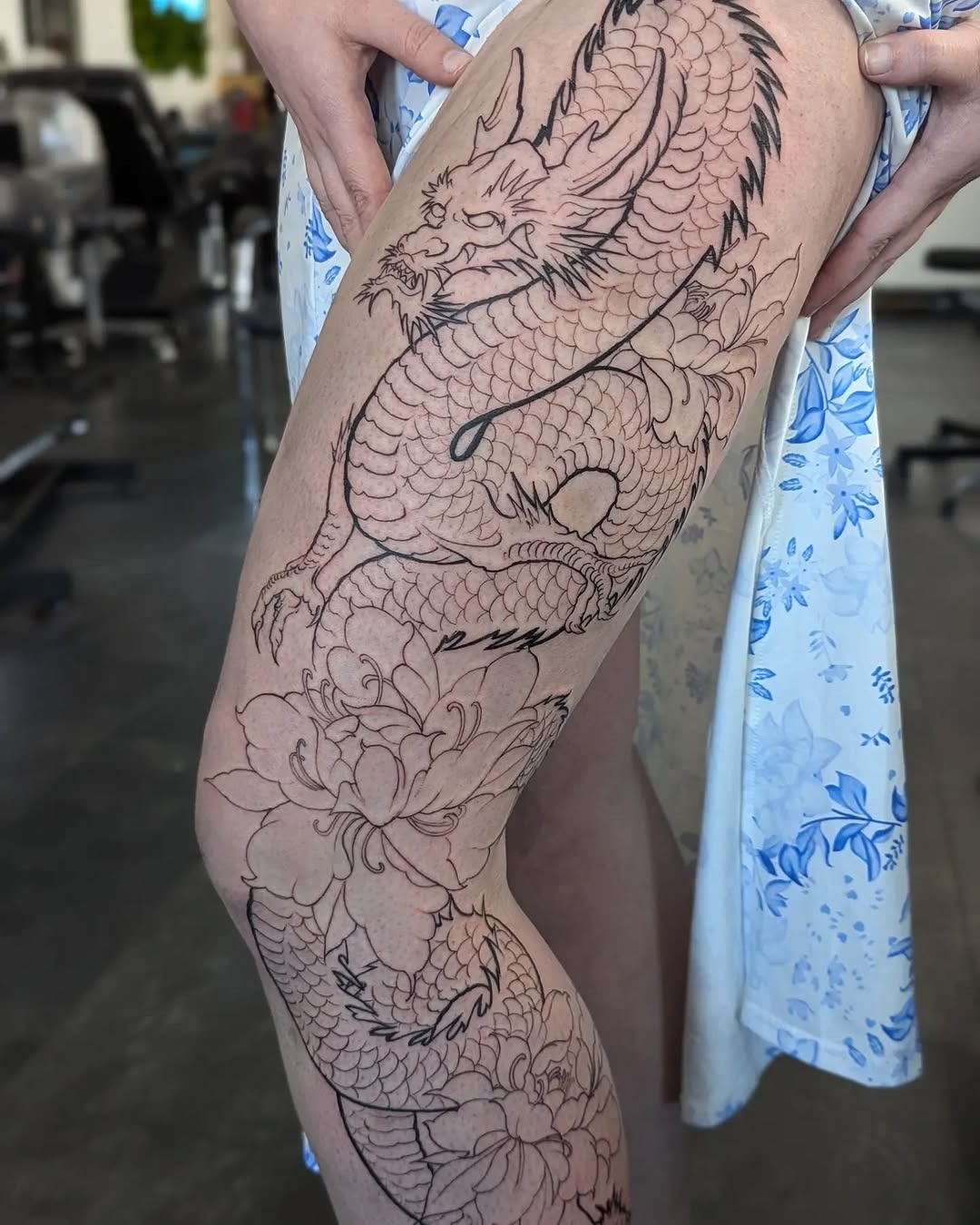 Intricate dragon tattoo entwined with floral elements Tattoo Design