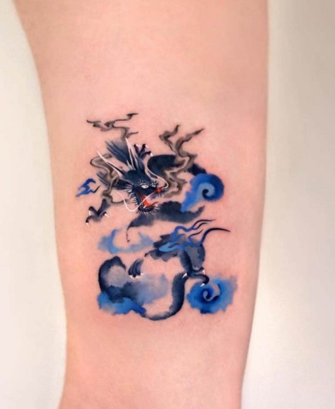 Stylish dragon tattoo emerging from swirling clouds Tattoo Design