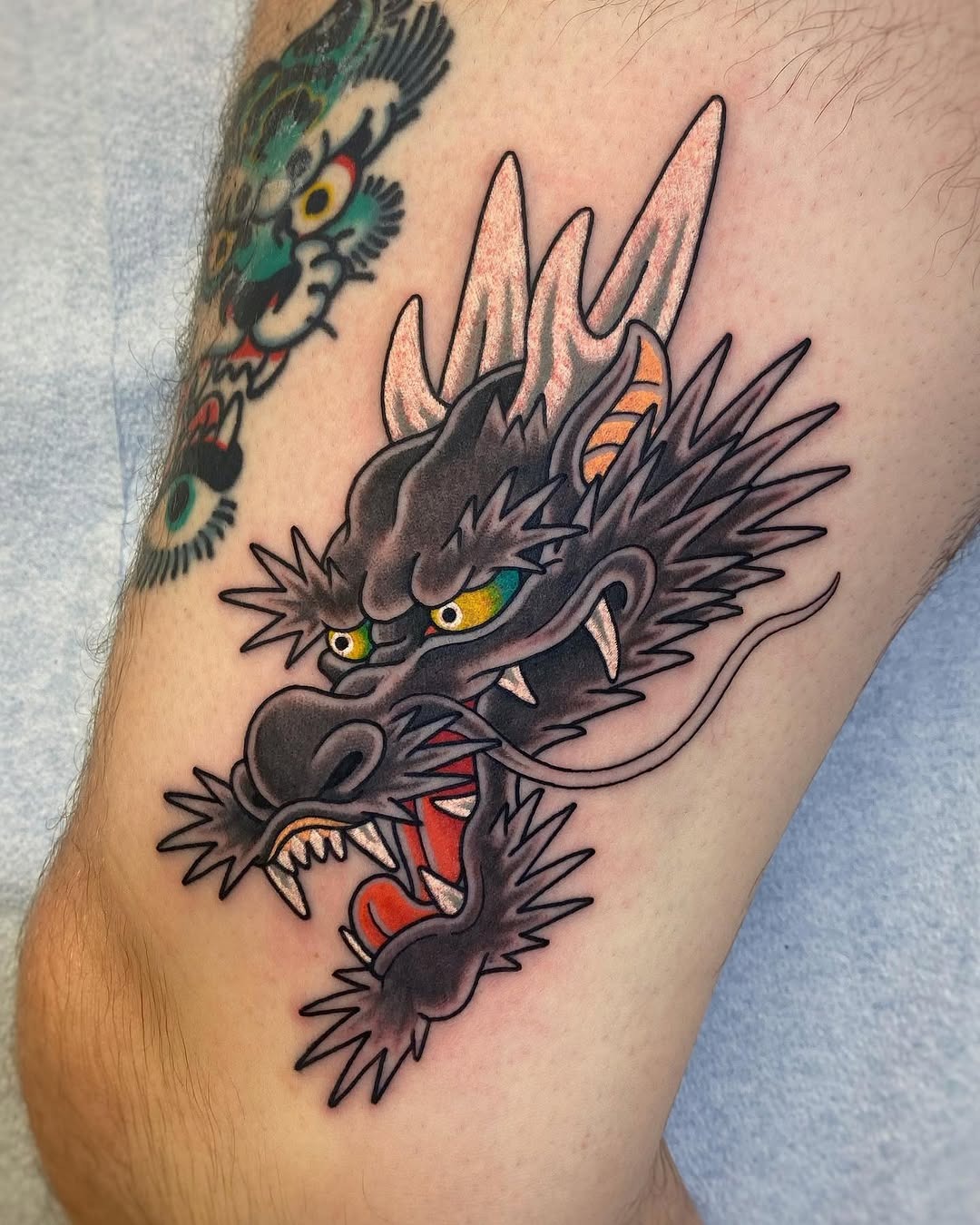 Vibrant dragon tattoo with fierce expression. Tattoo Design