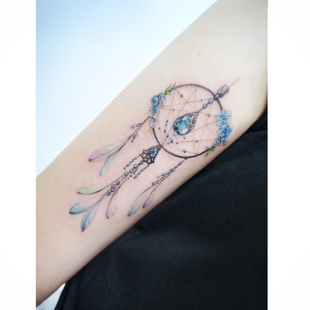 Colorful dreamcatcher tattoo adorned with flowers Tattoo Design