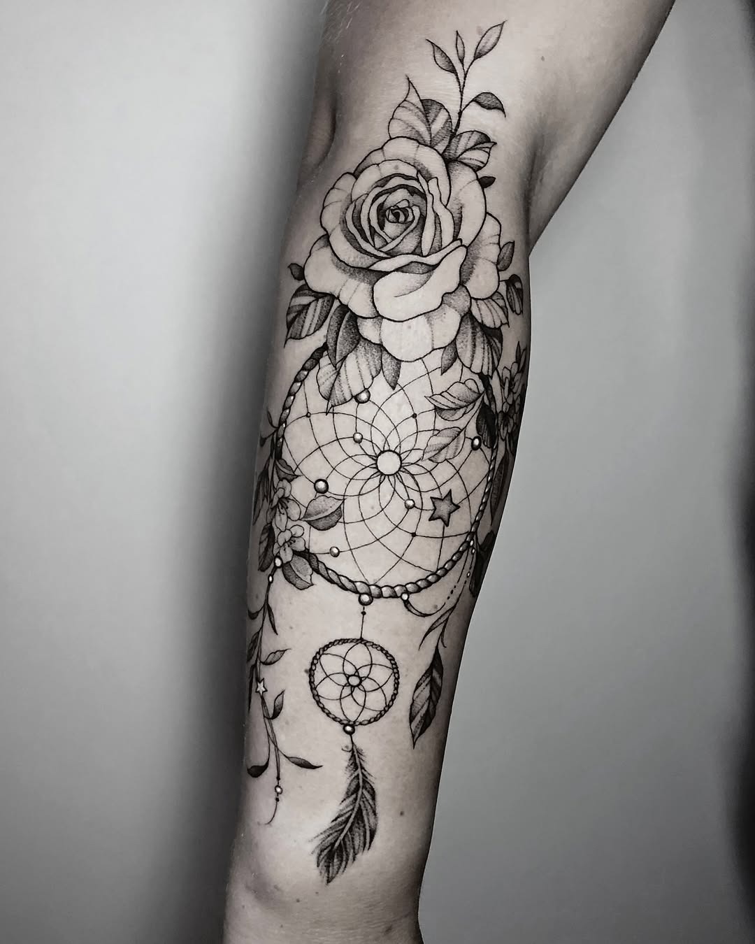 Elegant dreamcatcher tattoo entwined with roses Tattoo Design