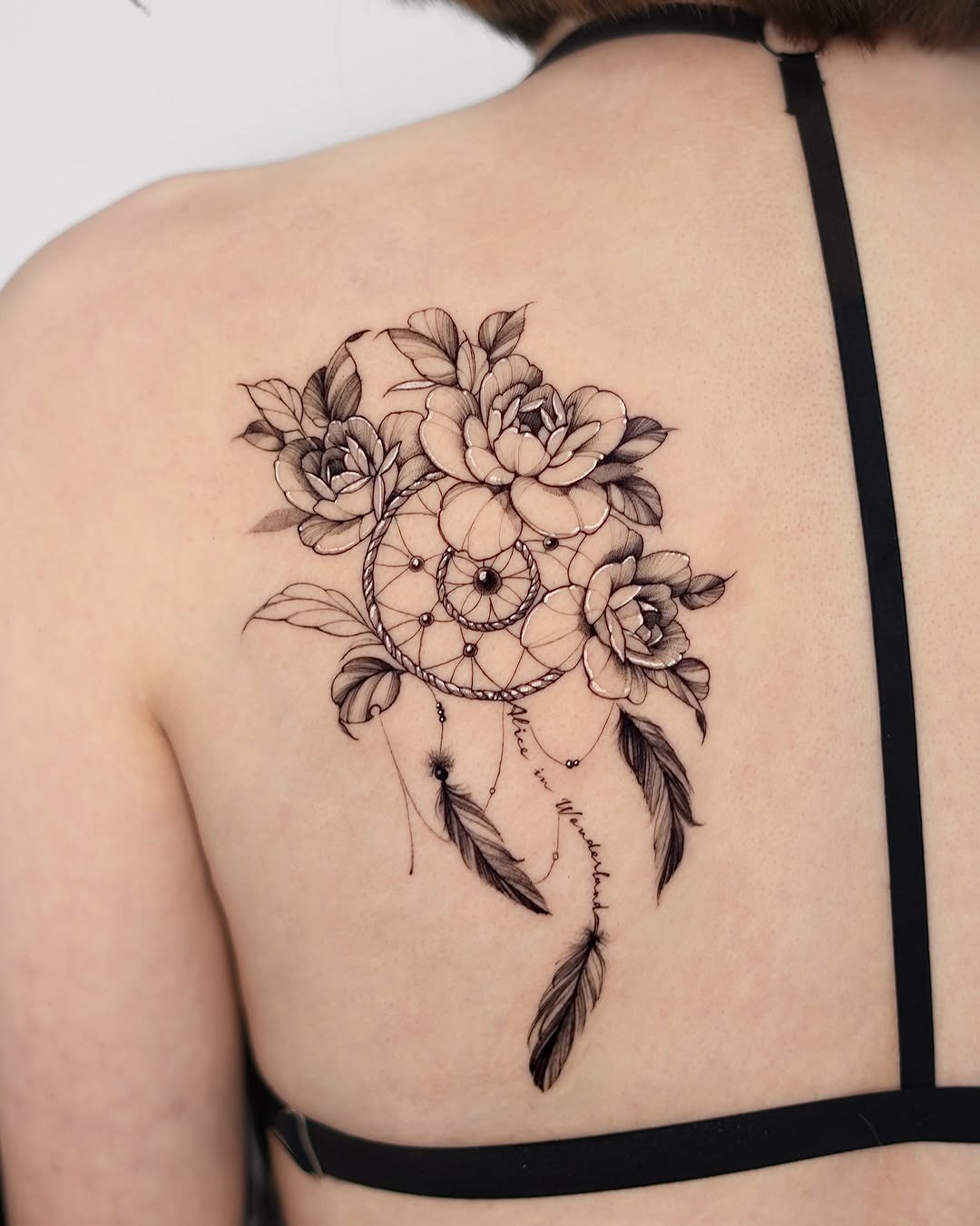 Intricate dreamcatcher tattoo adorned with flowers Tattoo Design