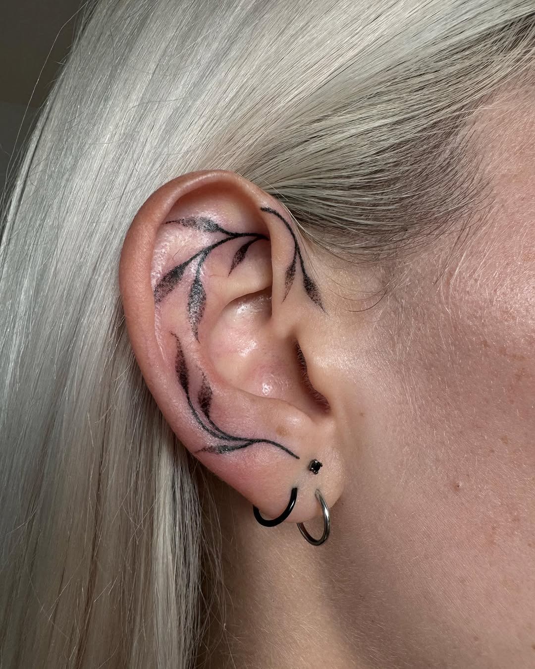 Elegant black line ear tattoo with floral motifs Tattoo Design