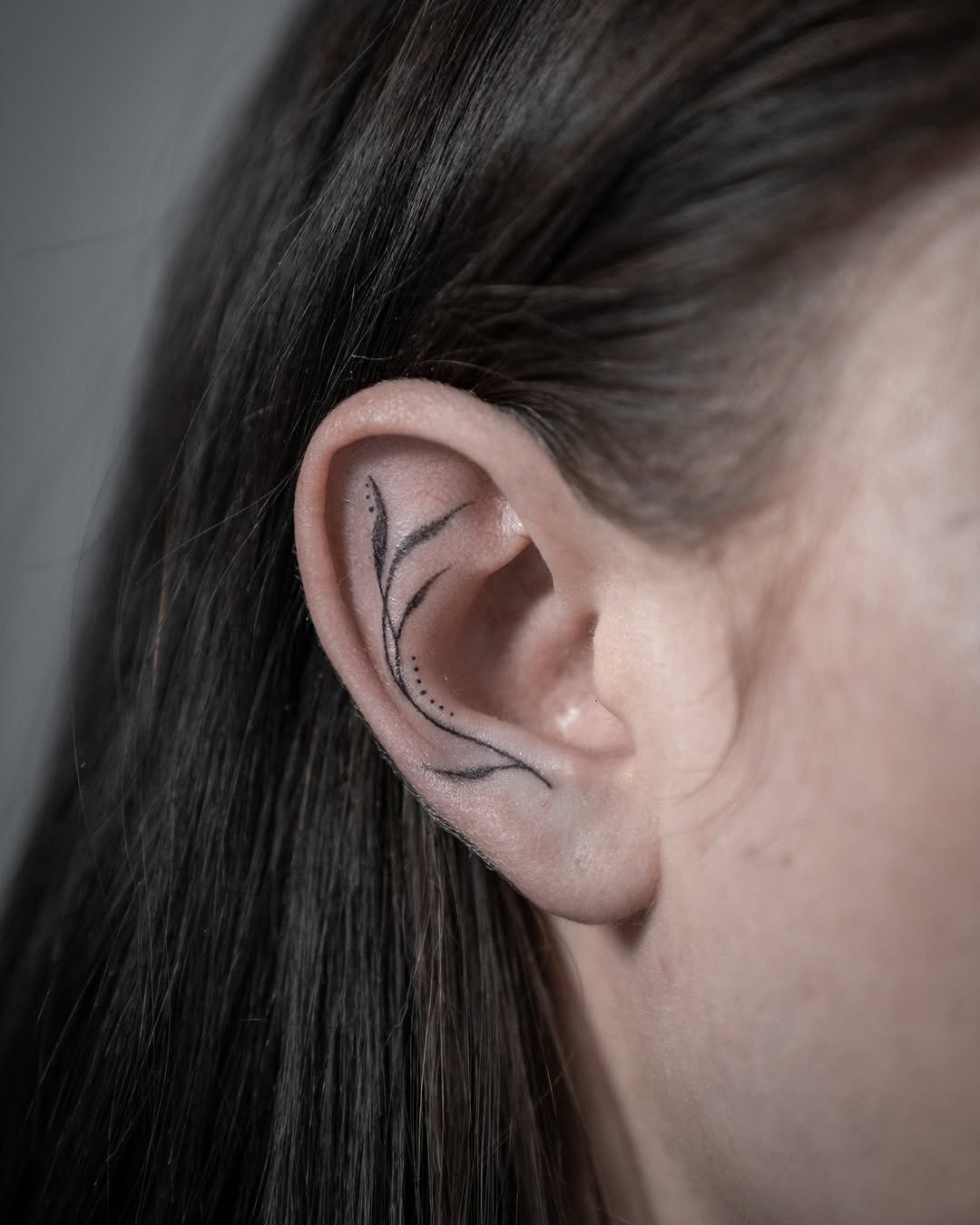Elegant floral design gracing the ear. Tattoo Design