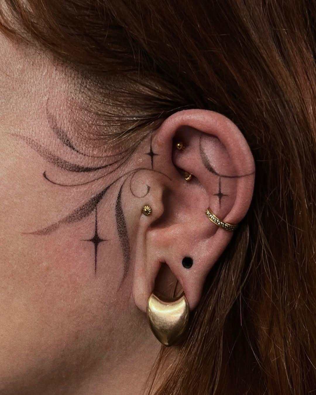 Elegant Floral Stars Adorning the Ear Tattoo Design