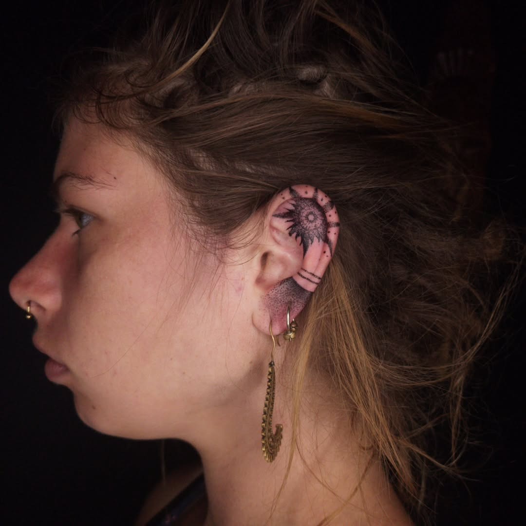 Stylish sun tattoo gracing the ear Tattoo Design