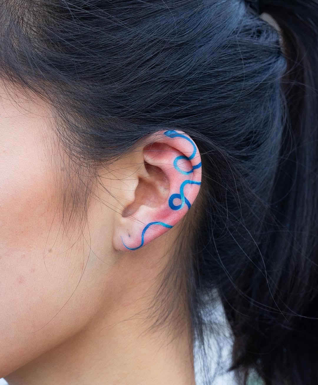 Stylish wavy line tattoo on the ear Tattoo Design