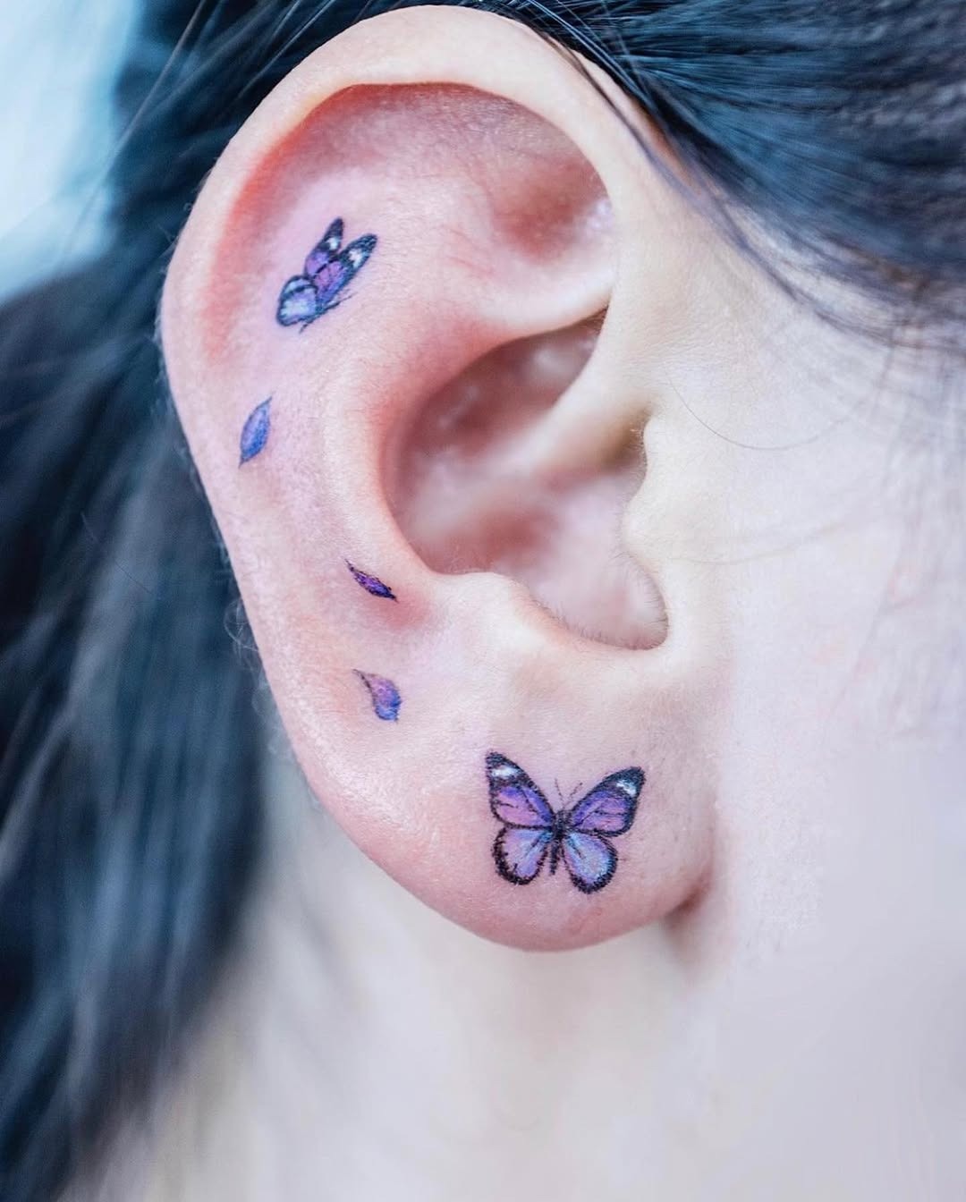 Vibrant butterfly tattoos adorning the ear Tattoo Design