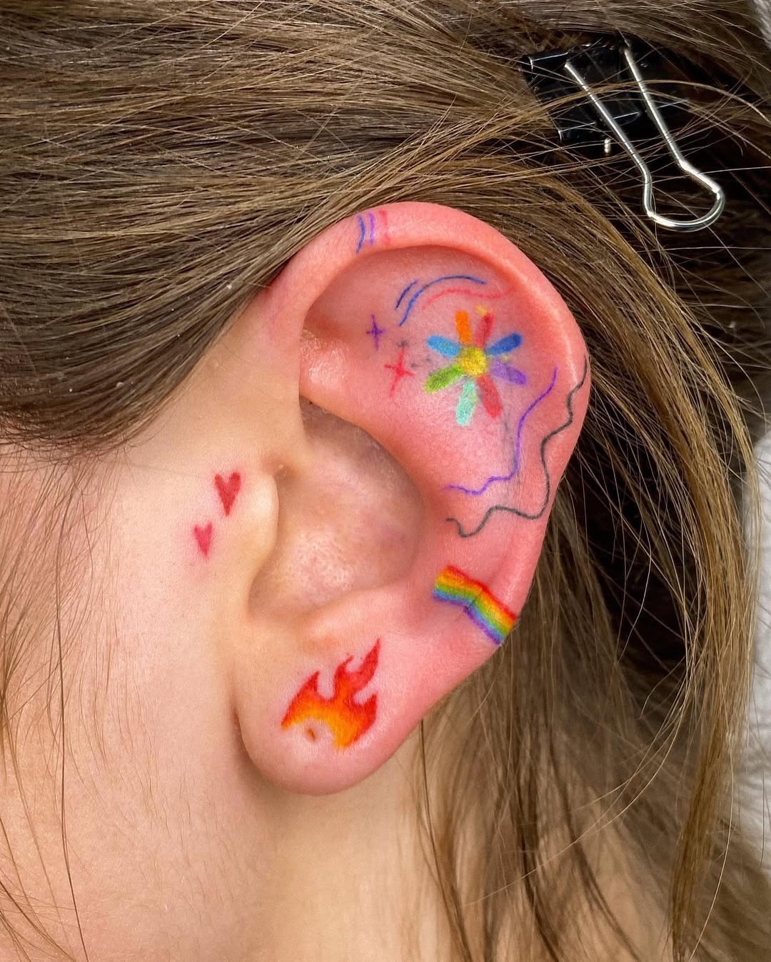 Vibrant ear tattoos with playful designs Tattoo Design