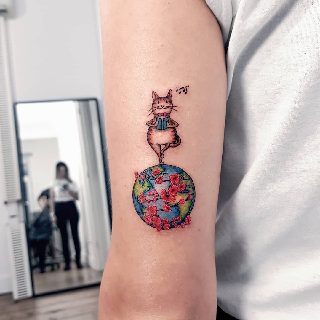 Whimsical cat tattoo on a vibrant globe Tattoo Design