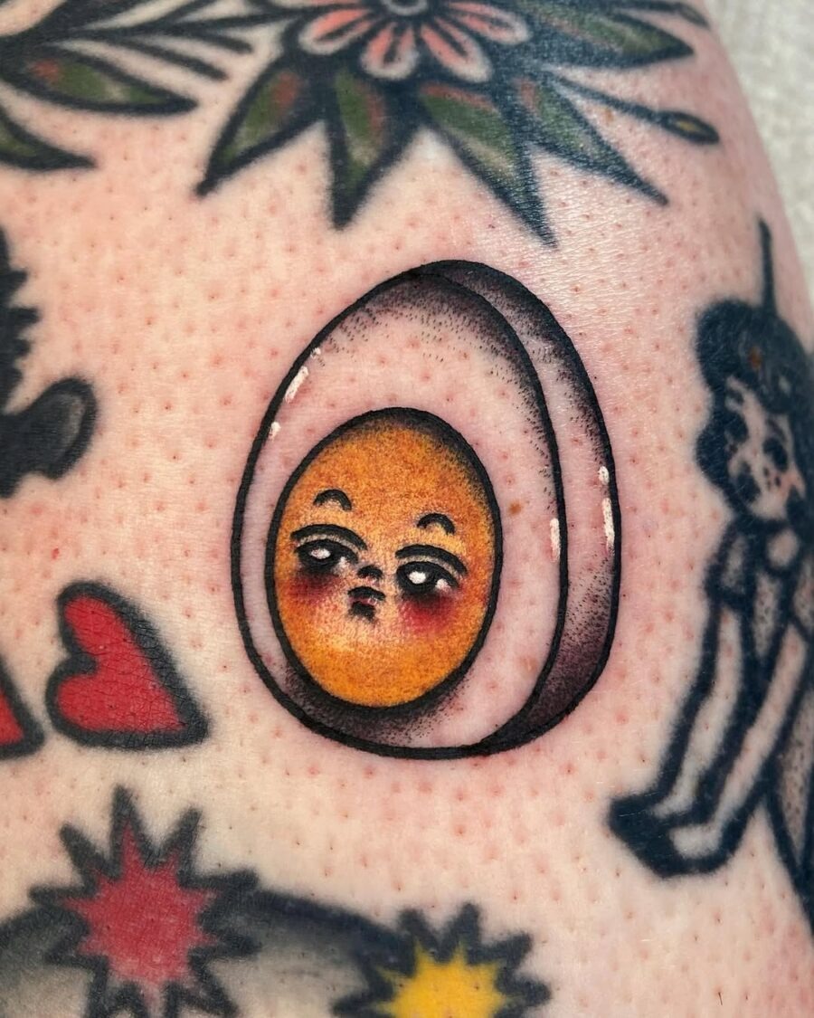 This unique egg tattoo features a stylized egg with a playful facial expression.