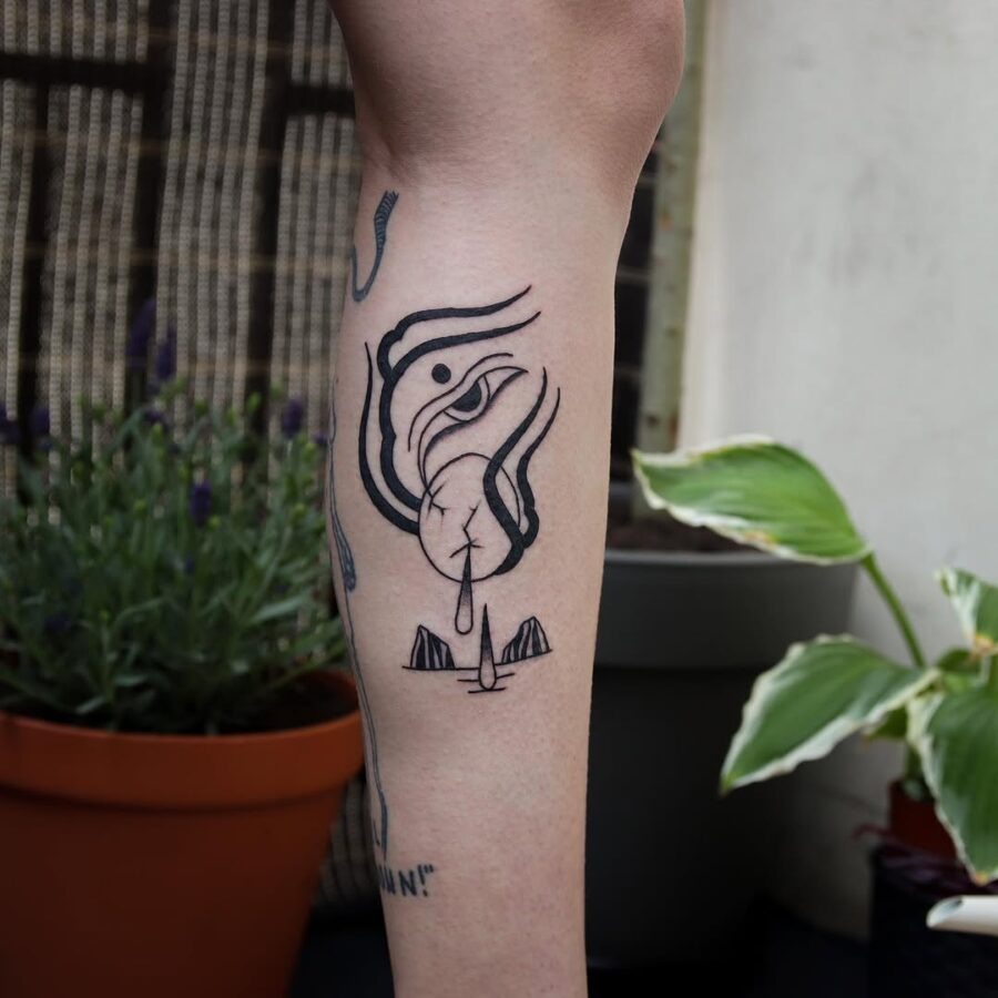 This tattoo features an abstract, black-ink design of an egg, cleverly intertwined with fluid lines.