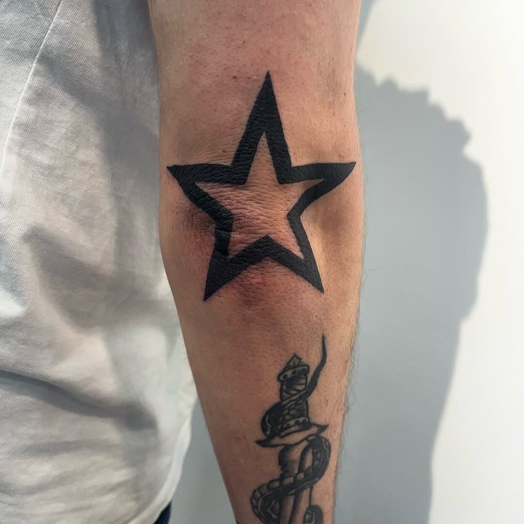 Bold star tattoo on the elbow Tattoo Design