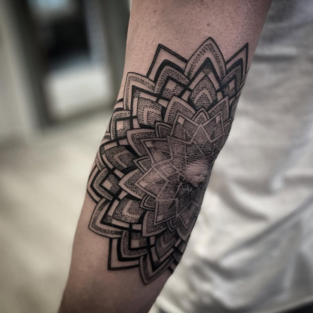 Intricate mandala elbow tattoo in black ink Tattoo Design