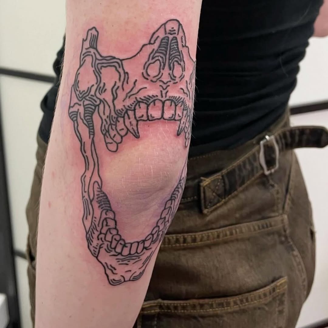 Intricate skull design enhances elbow tattoo uniqueness. Tattoo Design