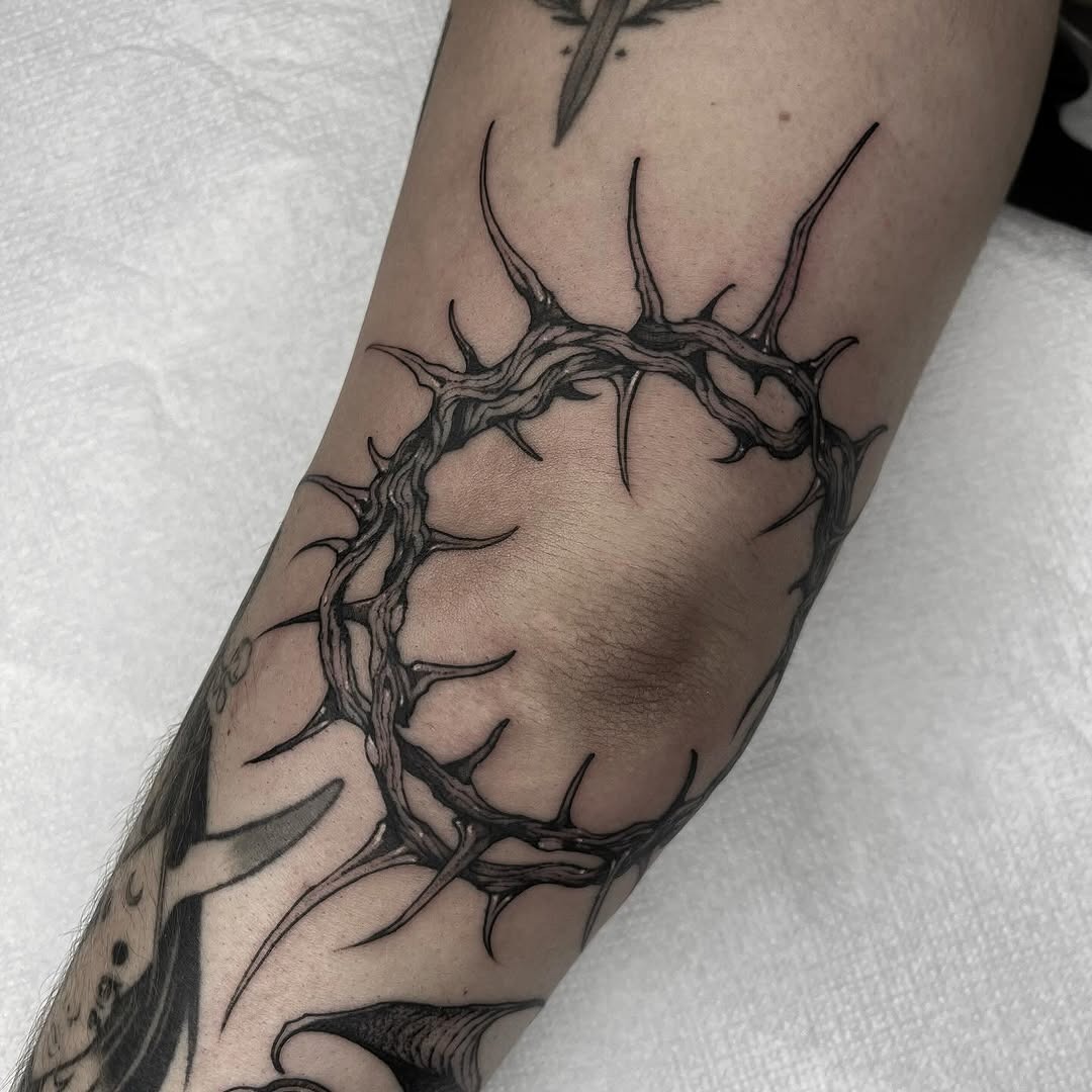 Intricate thorned circle tattoo on elbow Tattoo Design